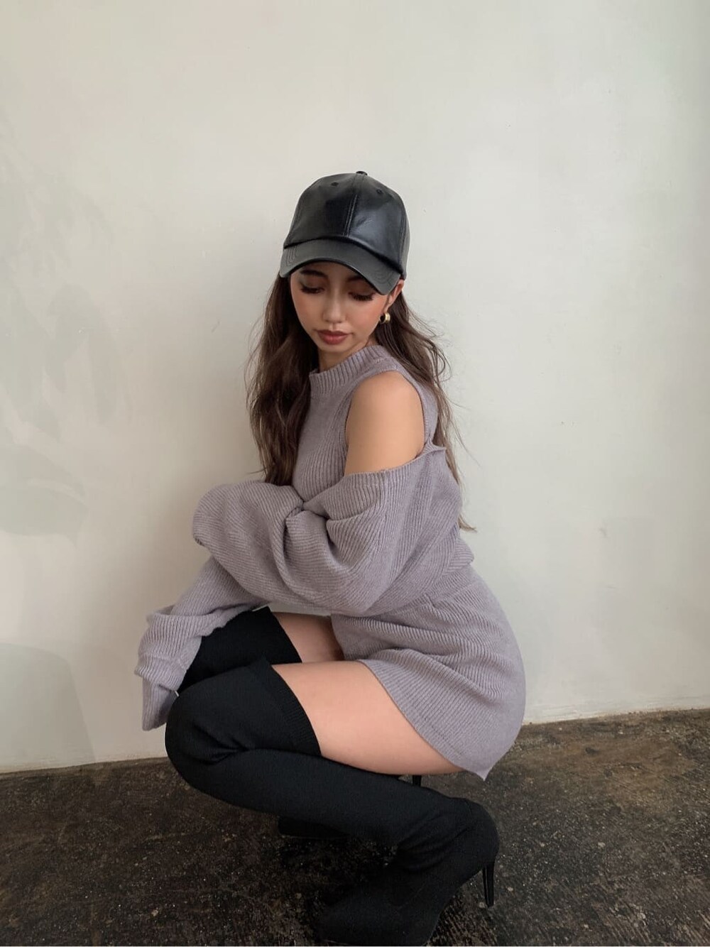 グレー系のつなぎ/オールインワン、ブラック系のブーツ、ブラック系のキャップを着用したレディースの秋コーディネートの4枚目の写真