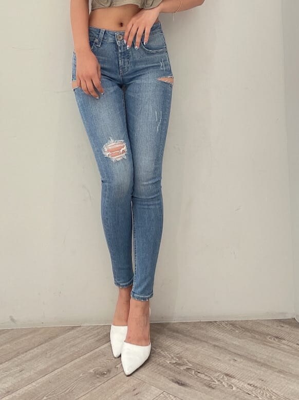 ホワイト系のパンプス、ブルー系のデニムパンツ、ゴールド系のピアス（両耳用）を着用したレディースの夏コーディネートの7枚目の写真