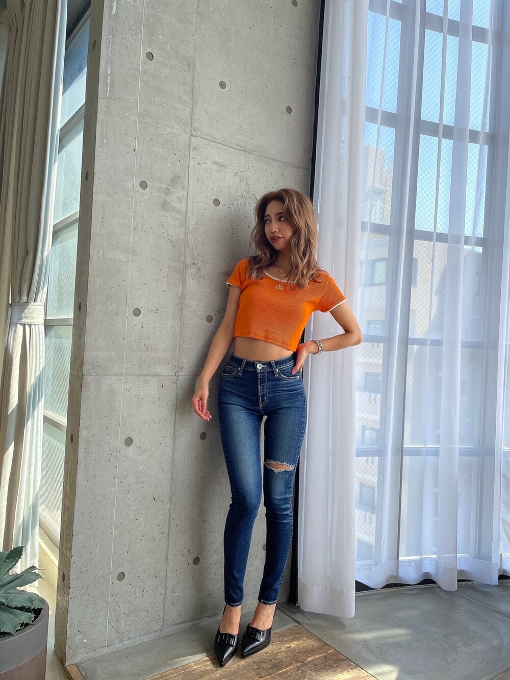 ブルー系のデニムパンツ、オレンジ系のTシャツ/カットソー、ブラック系のパンプスを着用したレディースの春コーディネートの4枚目の写真