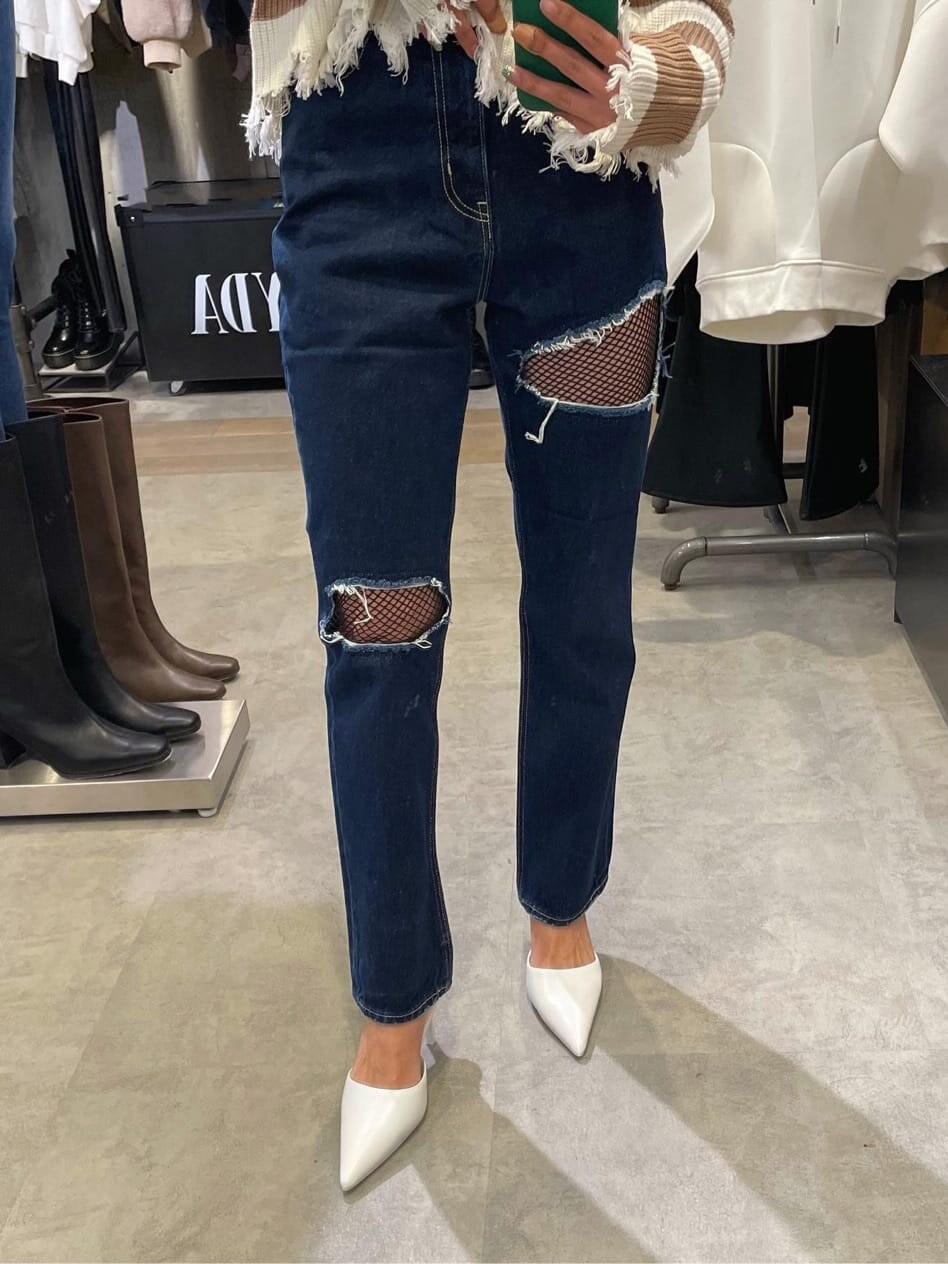 ホワイト系のパンプス、ベージュ系のニット/セーター、ブルー系のデニムパンツを着用したレディースの冬コーディネートの3枚目の写真