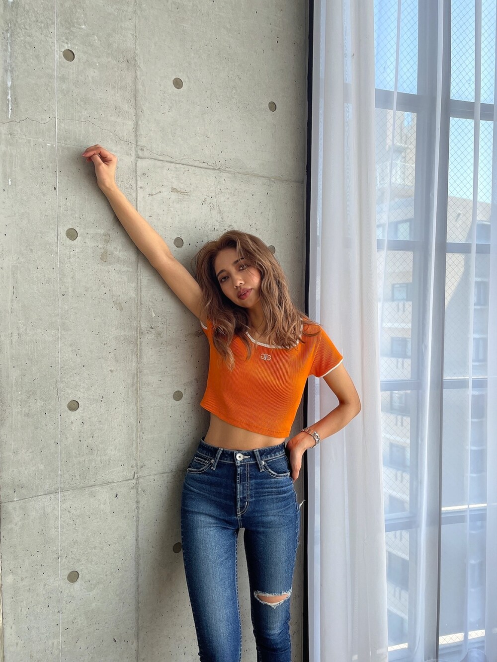 ブルー系のデニムパンツ、オレンジ系のTシャツ/カットソー、ブラック系のパンプスを着用したレディースの春コーディネートの6枚目の写真