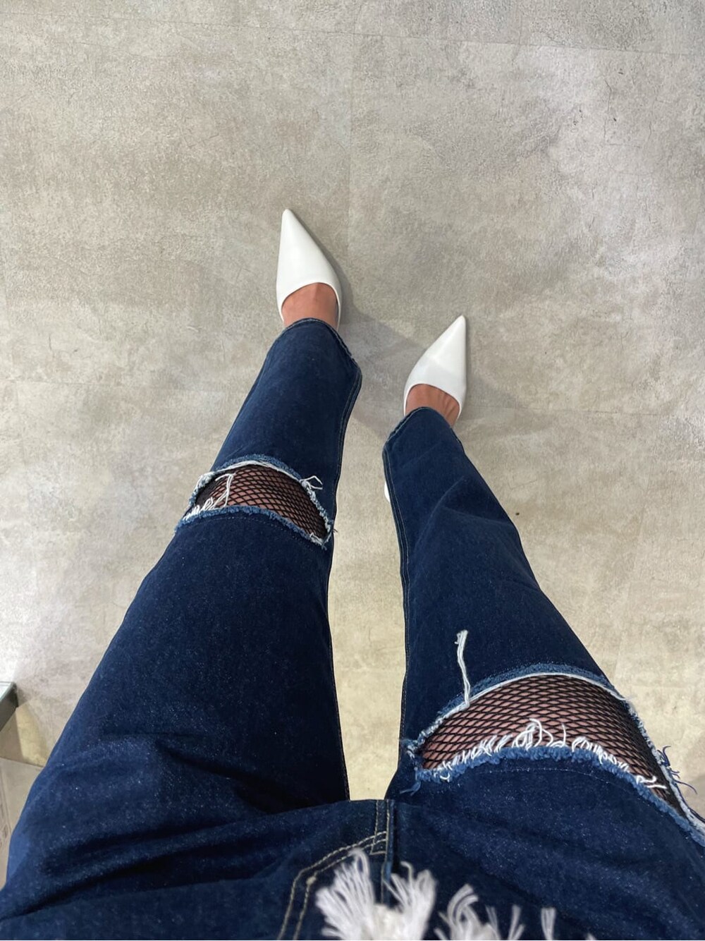 ホワイト系のパンプス、ベージュ系のニット/セーター、ブルー系のデニムパンツを着用したレディースの冬コーディネートの2枚目の写真