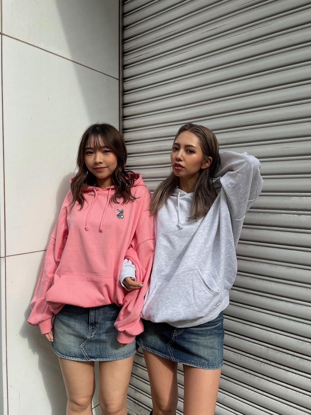 グレー系のパーカー、ピンク系のパーカー、ブルー系のデニムスカートを着用したレディースの冬コーディネートの5枚目の写真