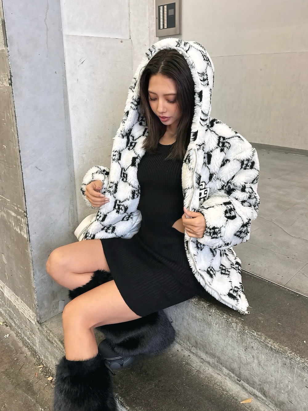 ホワイト系のブルゾン、ブラック系のワンピース、ブラック系のブーツを着用したレディースの秋コーディネートの6枚目の写真