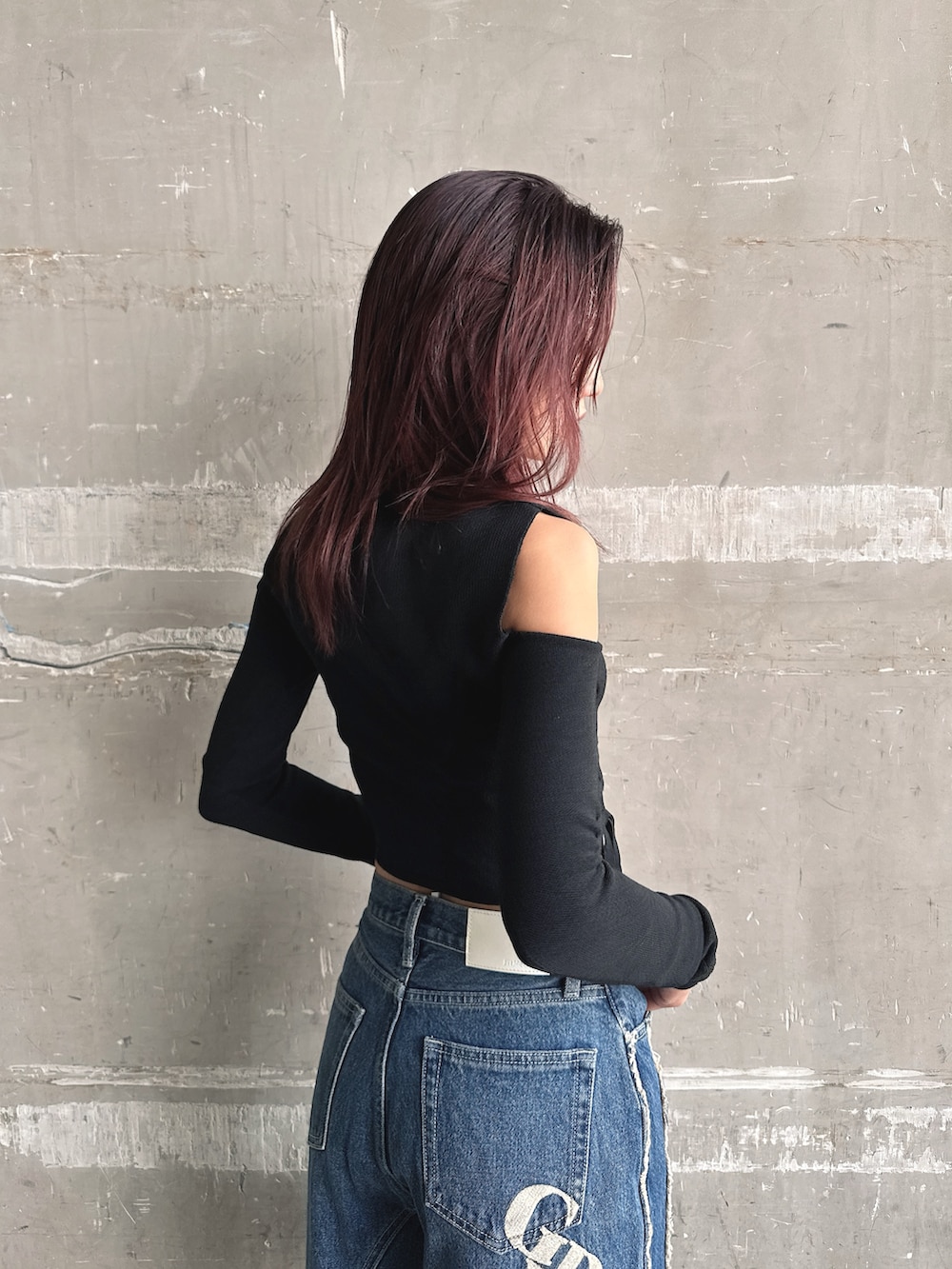 ブルー系のデニムパンツ、ブラック系のニット/セーター、ブラック系のハンドバッグを着用したレディースの秋コーディネートの7枚目の写真