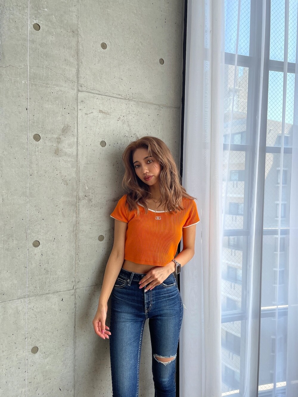 ブルー系のデニムパンツ、オレンジ系のTシャツ/カットソー、ブラック系のパンプスを着用したレディースの春コーディネートの7枚目の写真