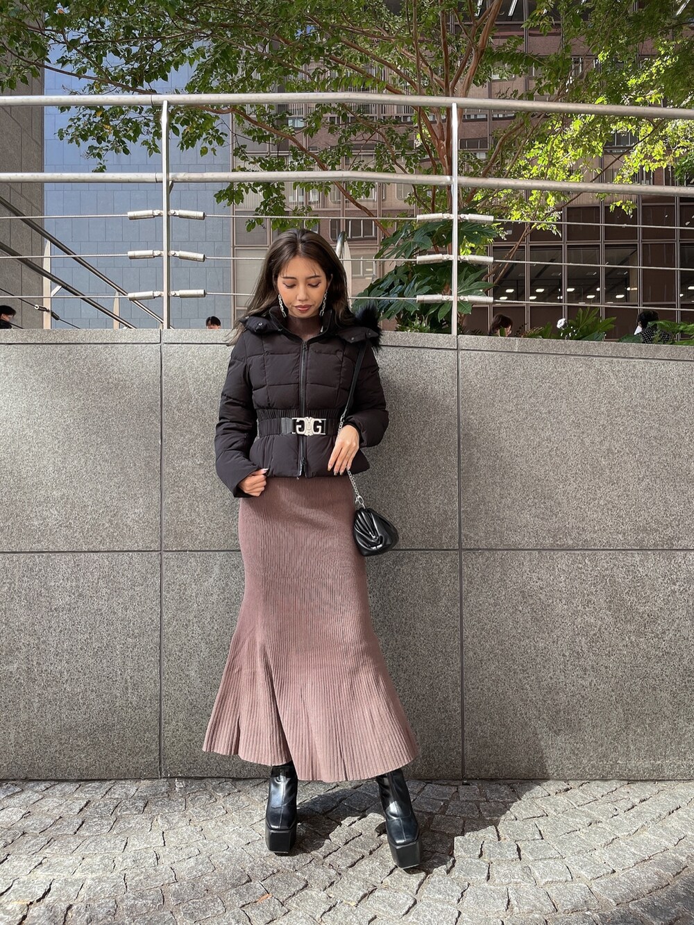 ブラック系のクラッチバッグ、ブラック系のブーツ、ブラウン系のワンピースを着用したレディースの秋コーディネートの7枚目の写真