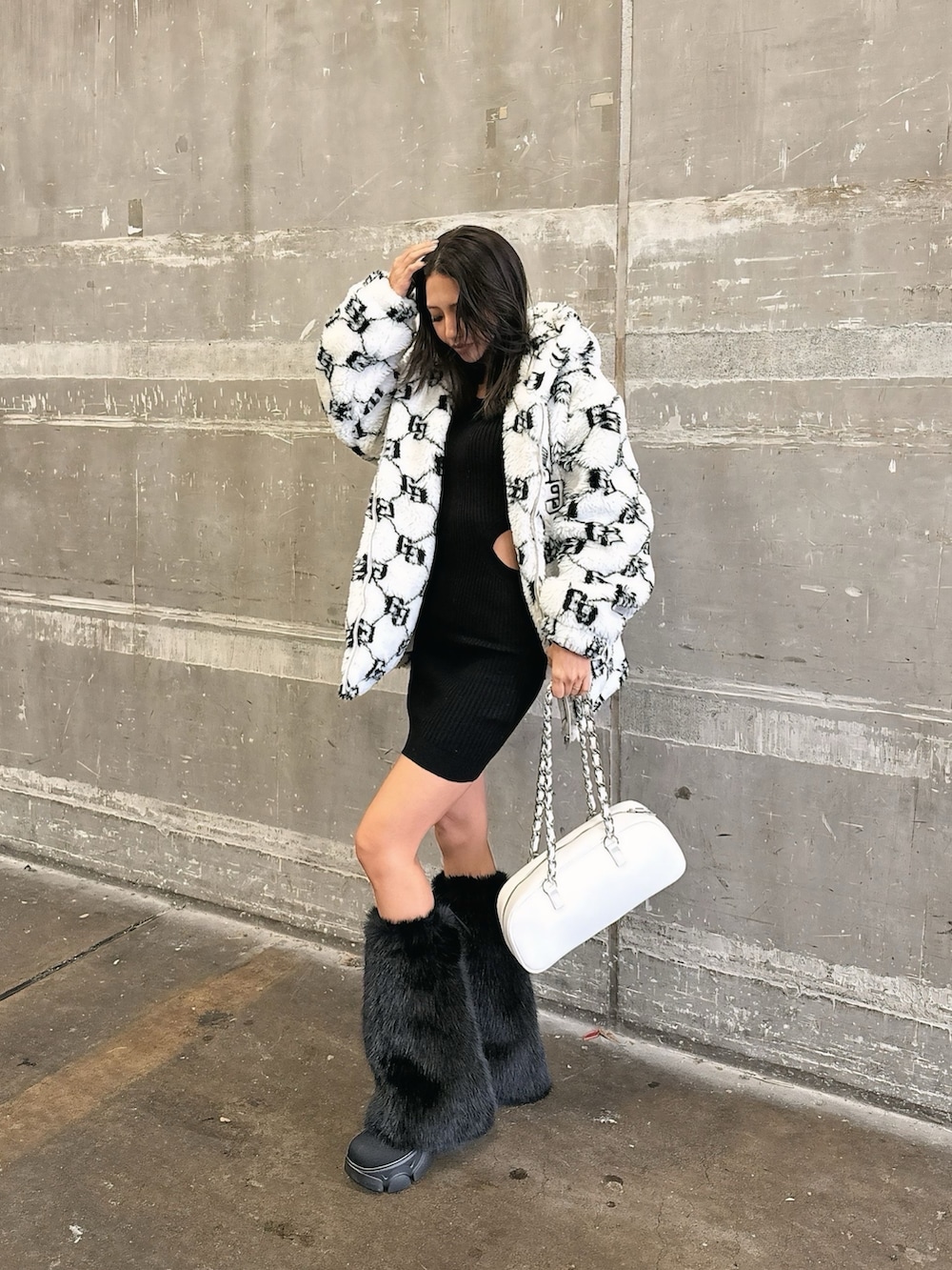 ホワイト系のブルゾン、ブラック系のワンピース、ブラック系のブーツを着用したレディースの秋コーディネートの7枚目の写真