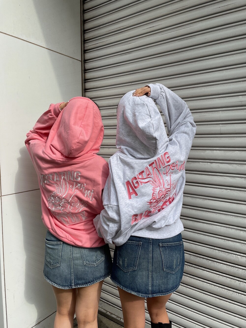 グレー系のパーカー、ピンク系のパーカー、ブルー系のデニムスカートを着用したレディースの冬コーディネートの7枚目の写真