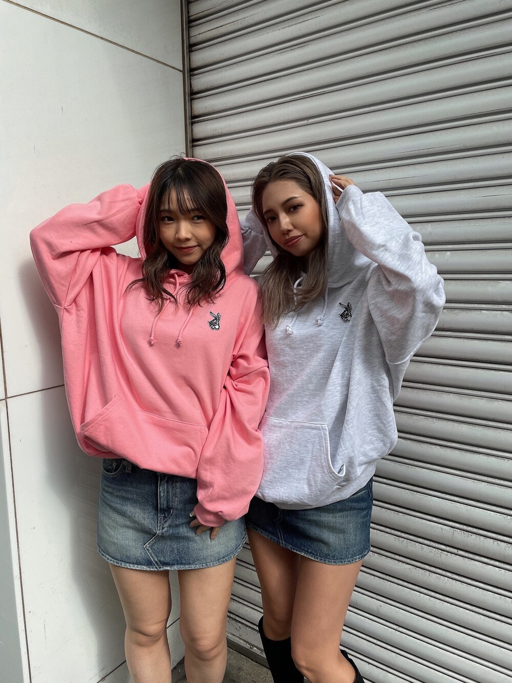 グレー系のパーカー、ピンク系のパーカー、ブルー系のデニムスカートを着用したレディースの冬コーディネートの4枚目の写真