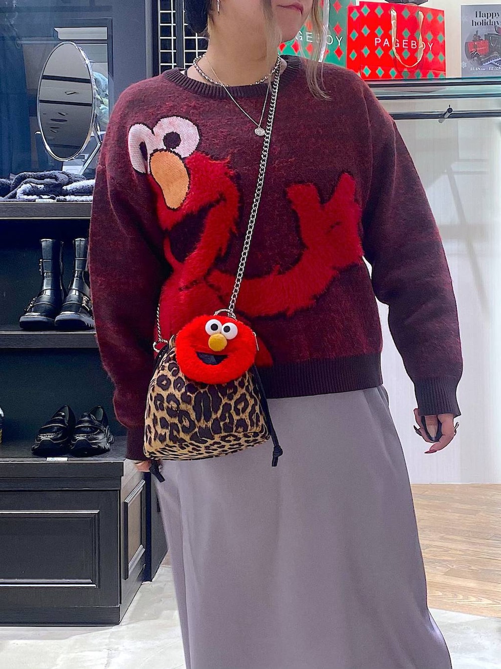 ブラック系のブーツ、その他のハンドバッグ、グレー系のスカートを着用したレディースの冬コーディネートの4枚目の写真