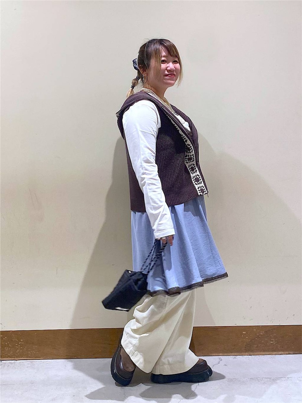 ブルー系のワンピース、その他のドレスシューズ、ブラック系のショルダーバッグを着用したレディースの秋コーディネートの2枚目の写真