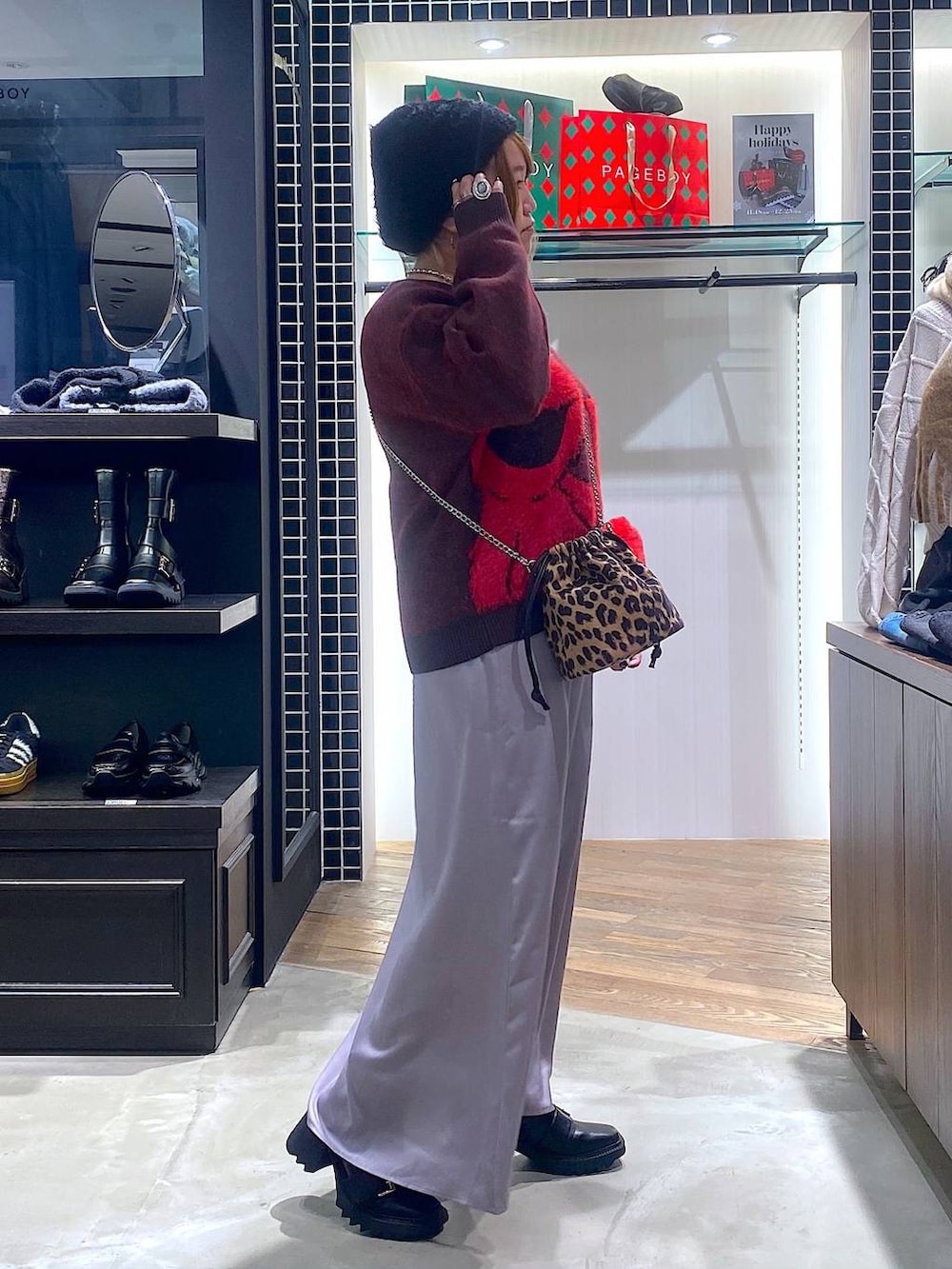 ブラック系のブーツ、その他のハンドバッグ、グレー系のスカートを着用したレディースの冬コーディネートの2枚目の写真