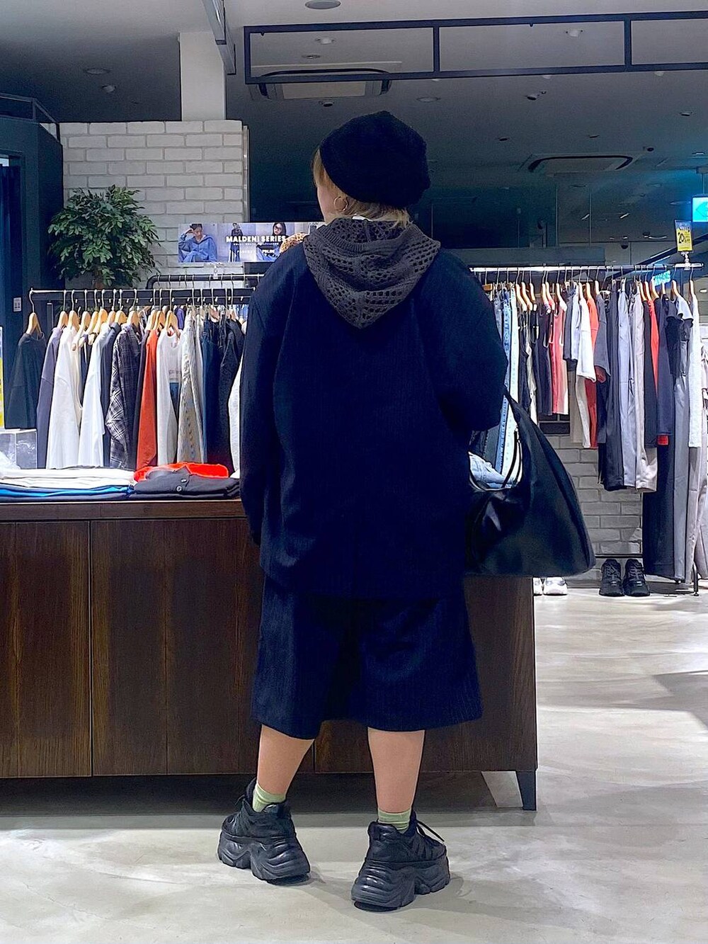 ブラック系のスニーカー、ピンク系のタンクトップ、ブラック系のトートバッグを着用したレディースの春コーディネートの3枚目の写真