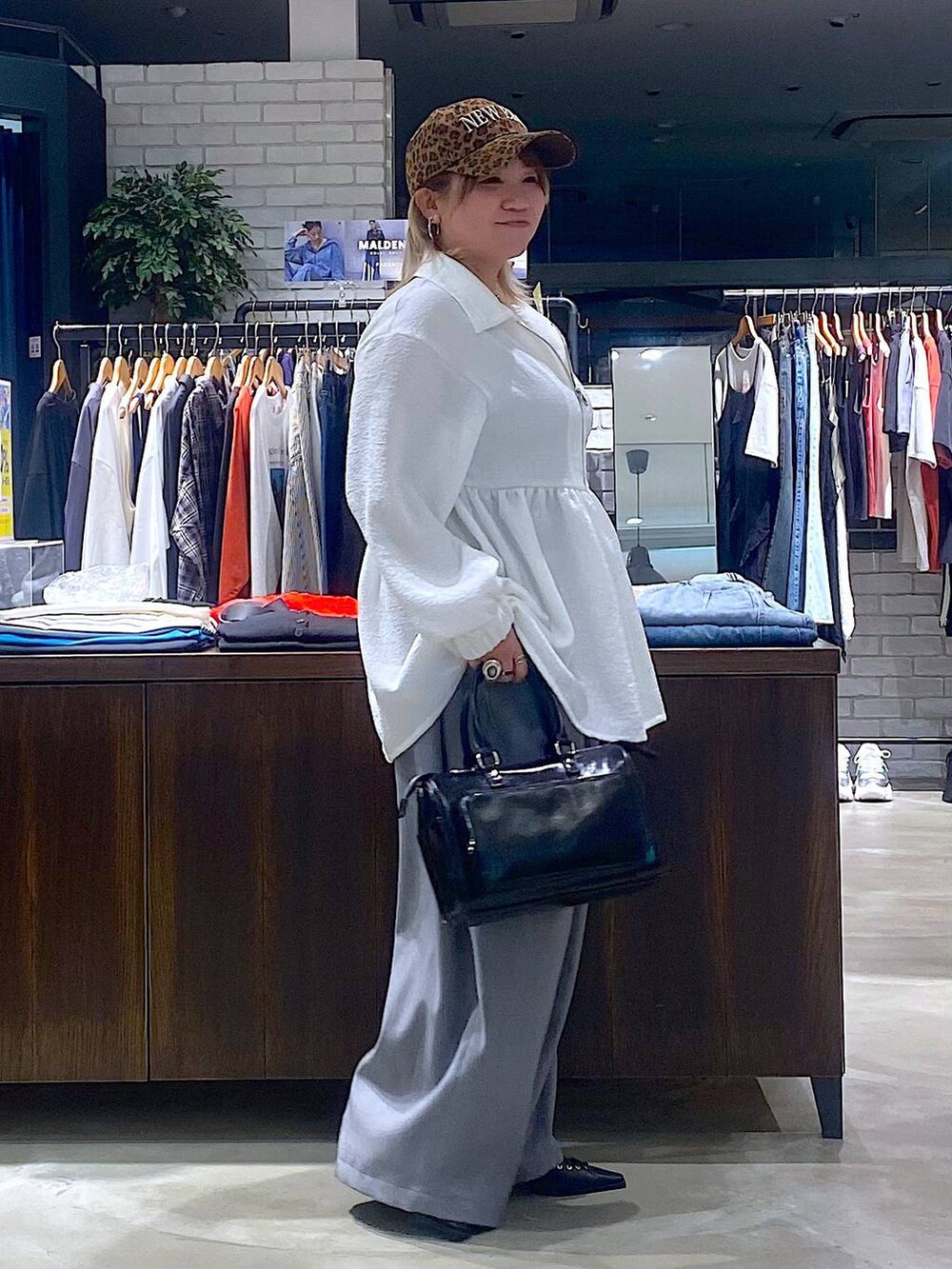 ブラック系のショルダーバッグ、グレー系のタンクトップ、ブラック系のサンダルを着用したレディースの春コーディネートの2枚目の写真