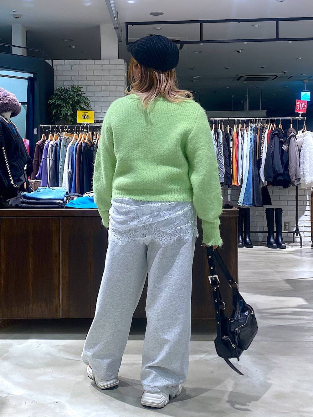 ベージュ系のスニーカー、ブラック系のショルダーバッグ、ホワイト系のTシャツ/カットソーを着用したレディースの冬コーディネートの3枚目の写真