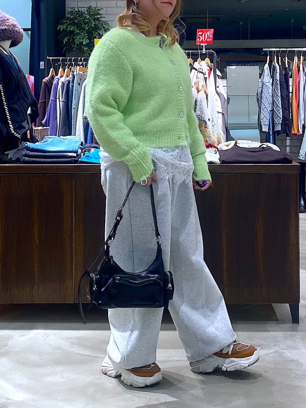 ベージュ系のスニーカー、ブラック系のショルダーバッグ、ホワイト系のTシャツ/カットソーを着用したレディースの冬コーディネートの2枚目の写真