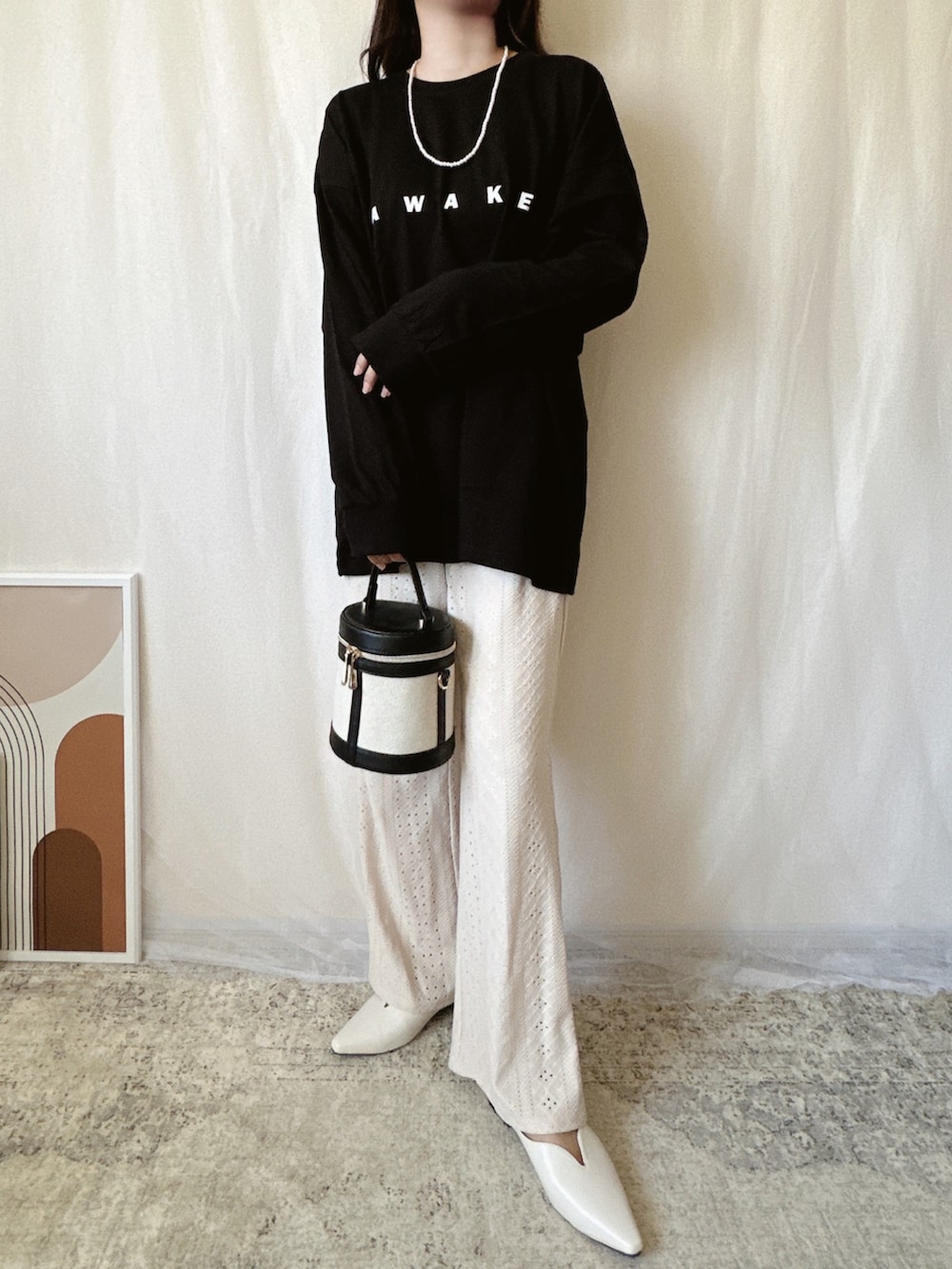 ブラック系のTシャツ/カットソーを着用したレディースの春コーディネートの2枚目の写真