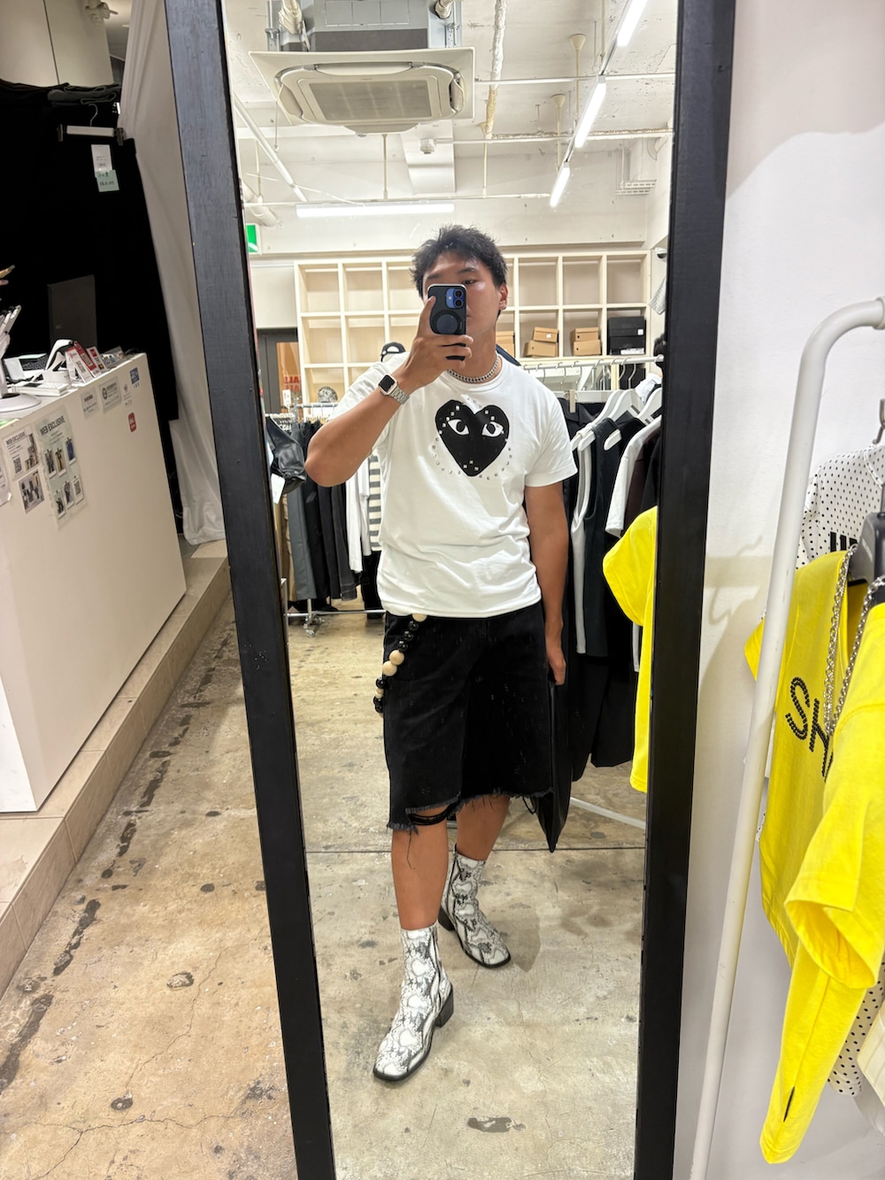 ブラック系のデニムパンツ、ホワイト系のブーツ、ホワイト系のトップスを着用したメンズの秋コーディネートの2枚目の写真