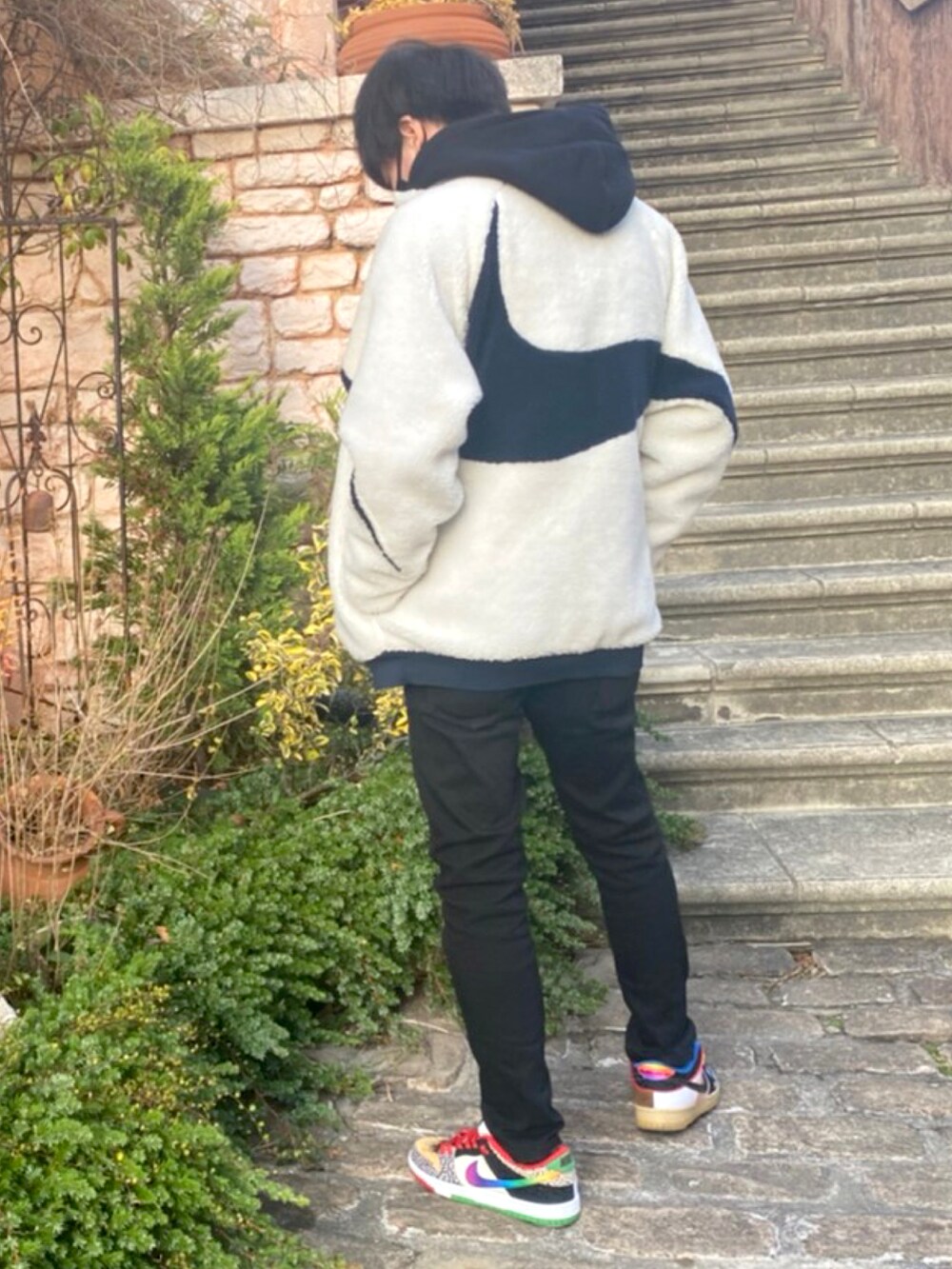 ブラック系のパーカー、ホワイト系のブルゾン、ブラック系のパンツを着用したメンズの冬コーディネートの2枚目の写真