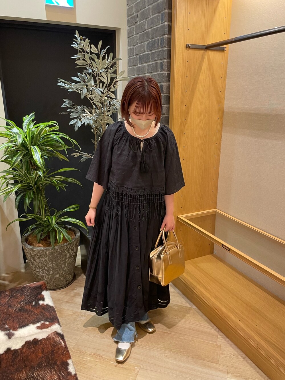 ブラック系のシャツ/ブラウス、ブラック系のワンピース、ブルー系のデニムパンツを着用したレディースの春コーディネートの2枚目の写真