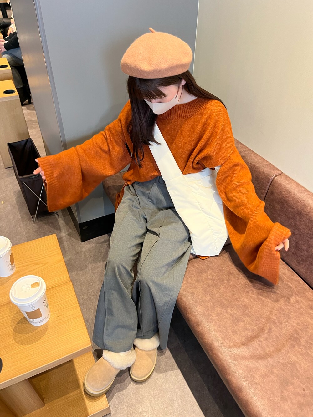 ホワイト系のショルダーバッグ、ベージュ系のパンツを着用したレディースの春コーディネートの2枚目の写真