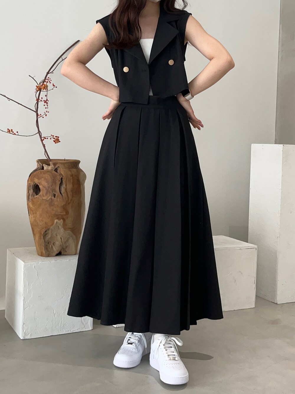 ブラウン系のベスト、ホワイト系のスニーカーを着用したレディースの夏コーディネートの2枚目の写真