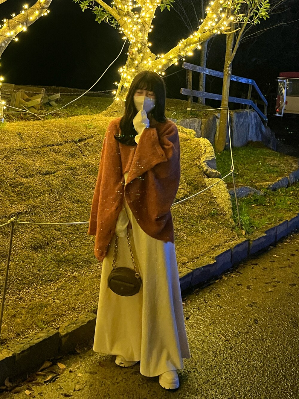 ブラウン系のバッグ、ベージュ系のブーツを着用したレディースの冬コーディネートの2枚目の写真