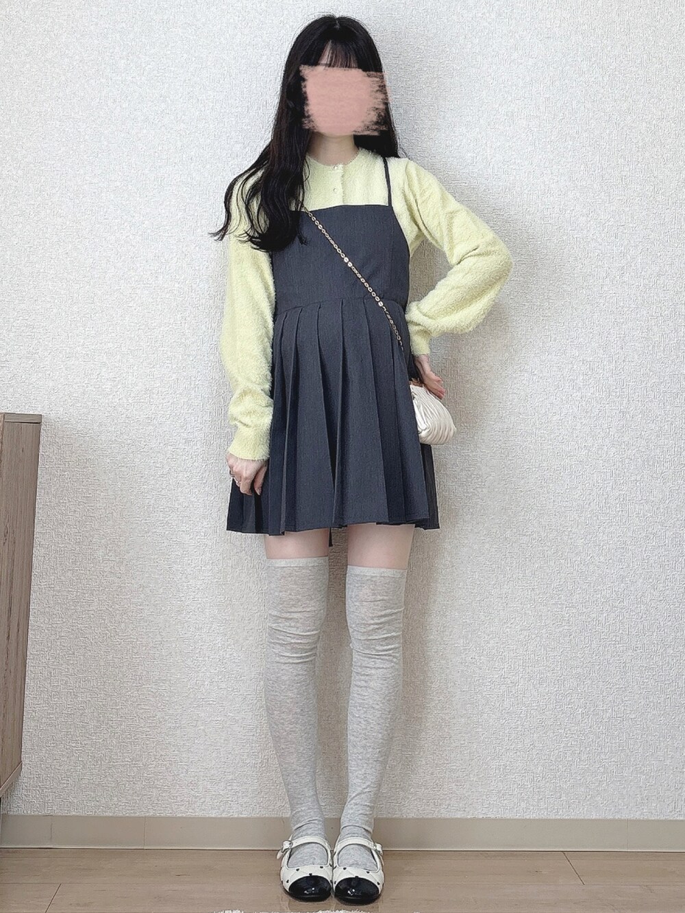 ベージュ系のショルダーバッグ、ホワイト系のパンプスを着用したレディースの冬コーディネートの2枚目の写真