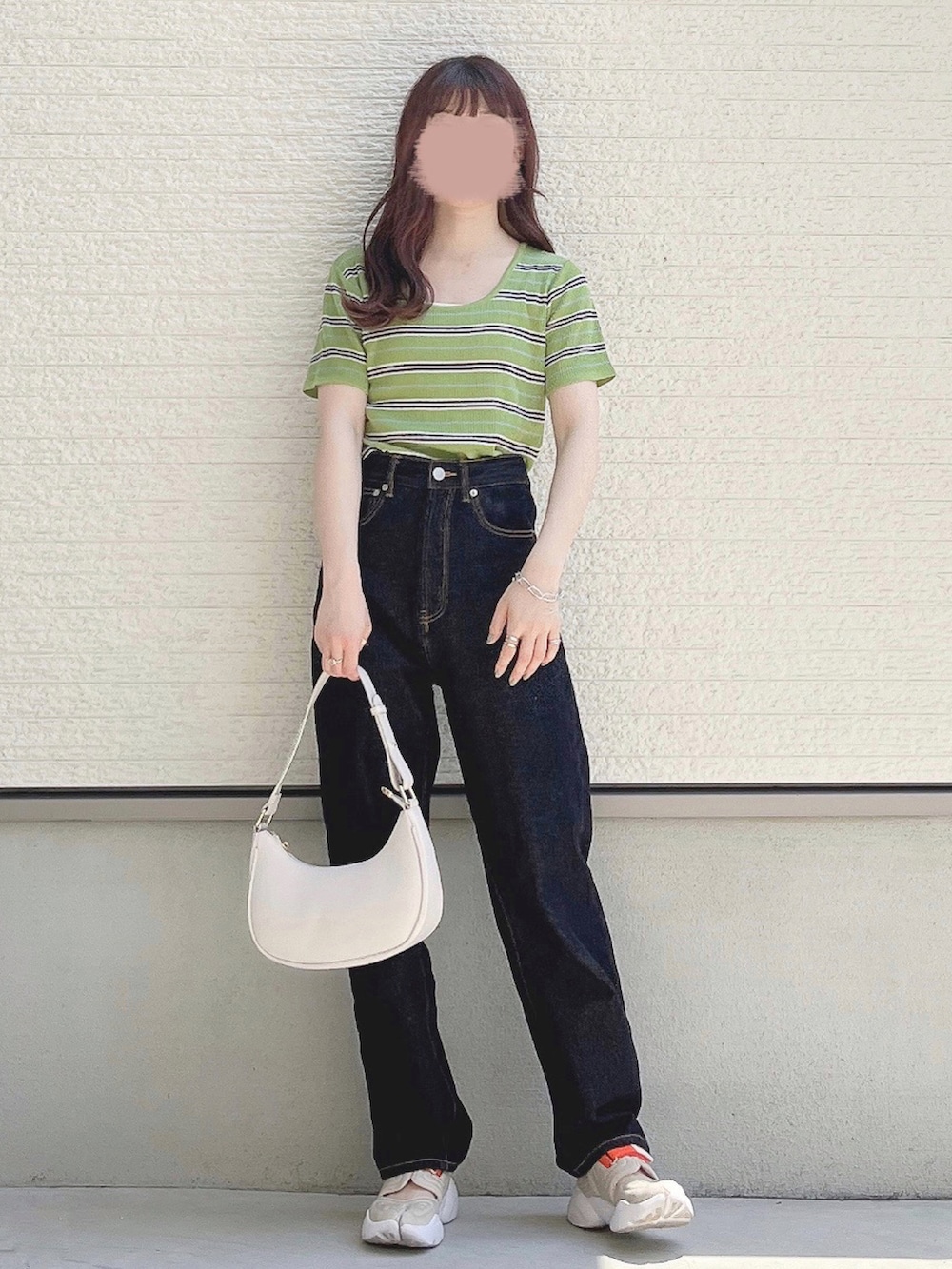 グリーン系のTシャツ/カットソー、ブラック系のデニムパンツ、ホワイト系のショルダーバッグを着用したレディースの春コーディネートの2枚目の写真
