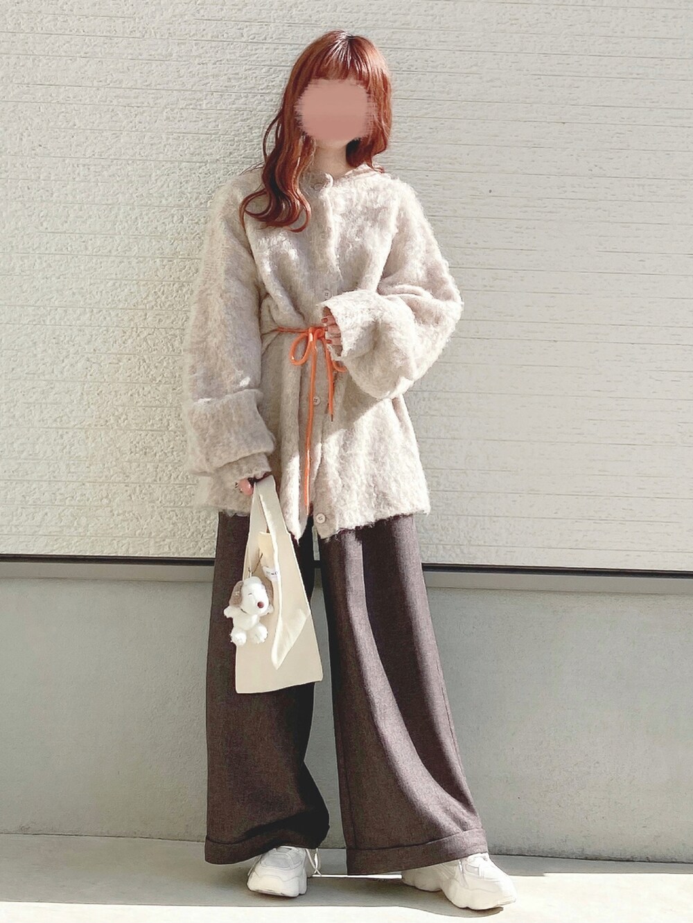 ホワイト系のカーディガン/ボレロ、グレー系のスラックス、ホワイト系のトートバッグを着用したレディースの秋コーディネートの2枚目の写真