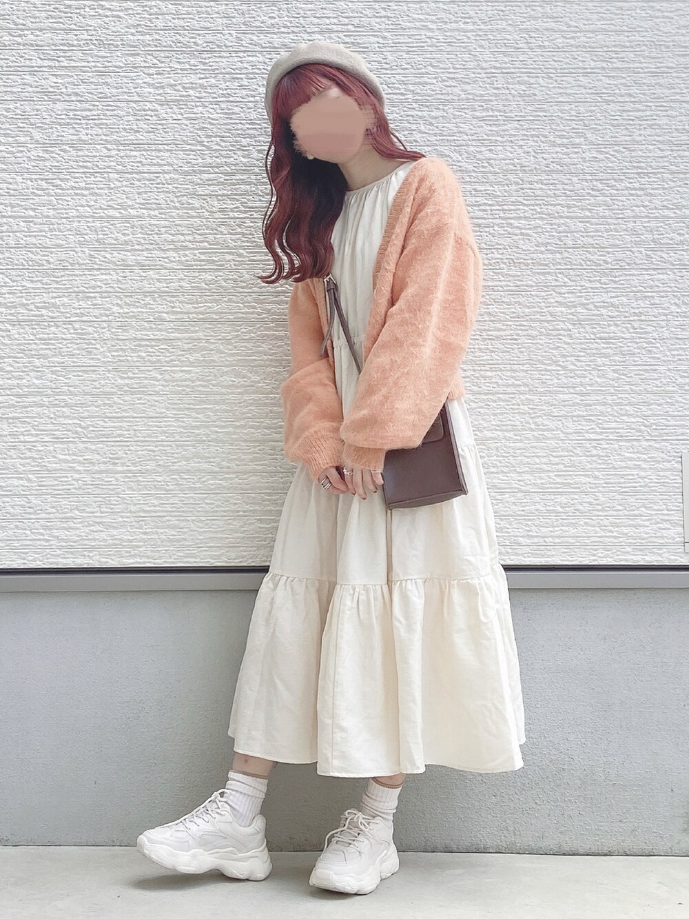 ホワイト系のワンピース、オレンジ系のカーディガン/ボレロ、ブラウン系のショルダーバッグを着用したレディースの秋コーディネートの3枚目の写真