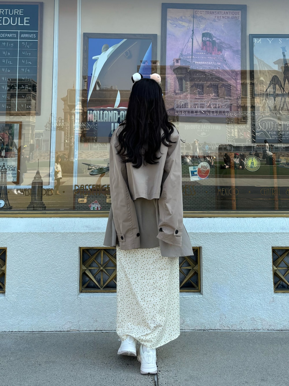 イエロー系のトレンチコート、イエロー系のワンピースを着用したレディースの春コーディネートの2枚目の写真