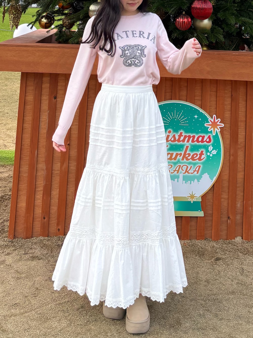 ピンク系のニット/セーター、ホワイト系のスカートを着用したレディースの冬コーディネートの2枚目の写真