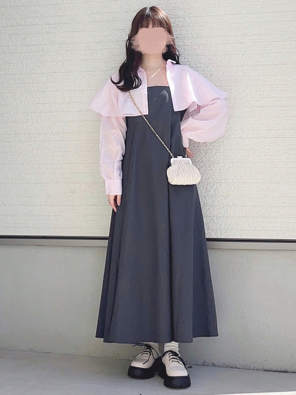 ホワイト系のワンピース、ベージュ系のショルダーバッグ、グレー系のジャンパースカートを着用したレディースの春コーディネートの2枚目の写真