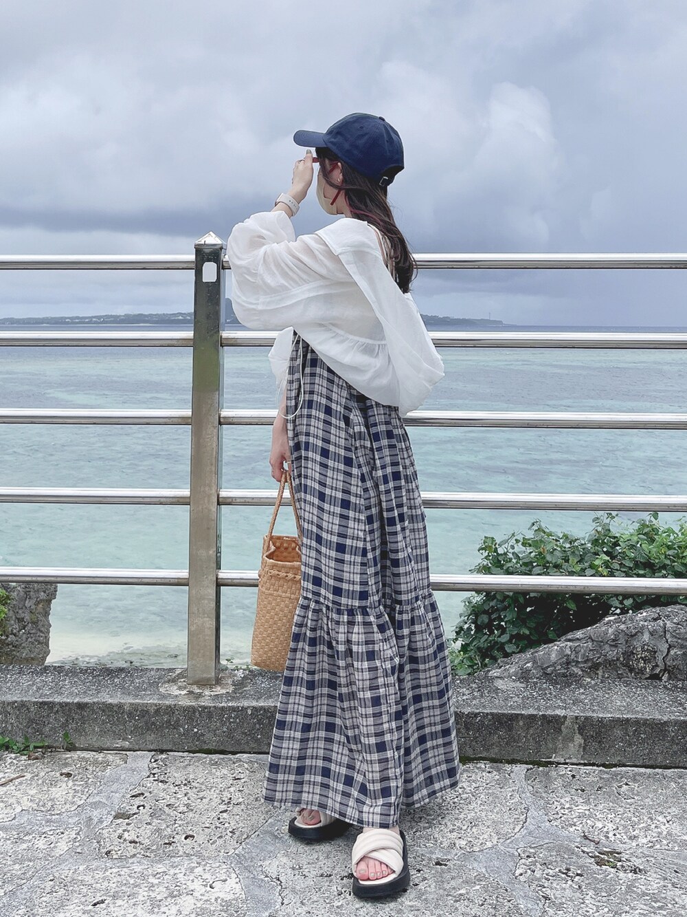ブルー系のワンピース、ホワイト系のブルゾン、ホワイト系のサンダルを着用したレディースの夏コーディネートの3枚目の写真