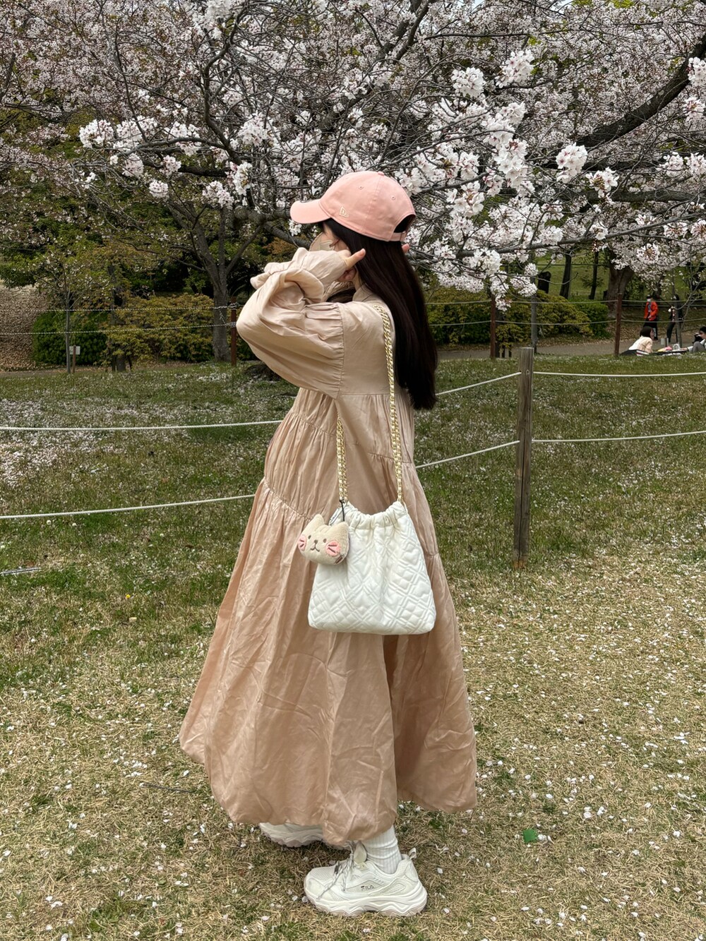 ピンク系のワンピースを着用したレディースの春コーディネートの2枚目の写真