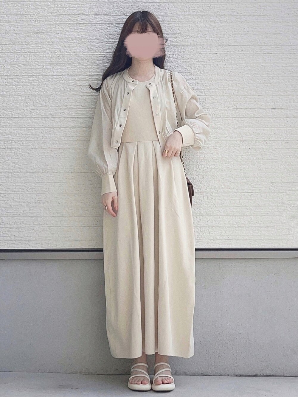 ベージュ系のブルゾン、ベージュ系のワンピース、ホワイト系のサンダルを着用したレディースの春コーディネートの2枚目の写真