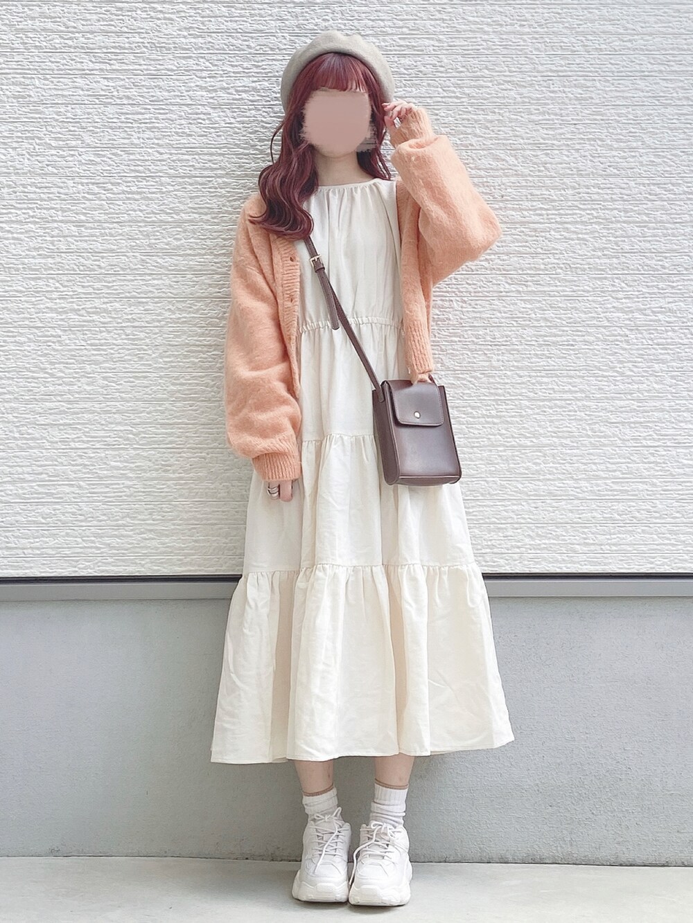 ホワイト系のワンピース、オレンジ系のカーディガン/ボレロ、ブラウン系のショルダーバッグを着用したレディースの秋コーディネートの2枚目の写真