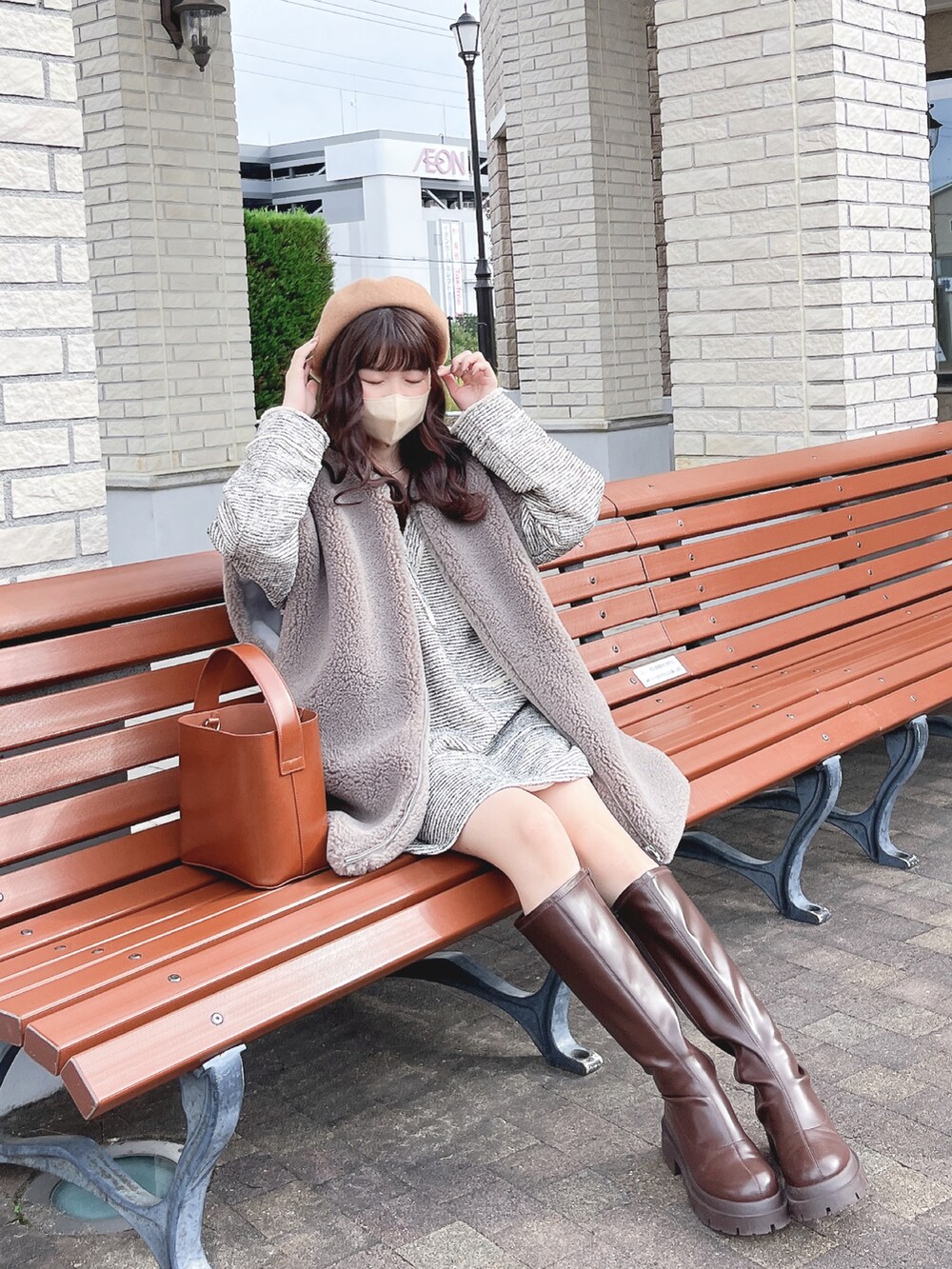 グレー系のベスト、ベージュ系のその他トップス、ブラウン系のハンドバッグを着用したレディースの秋コーディネートの2枚目の写真