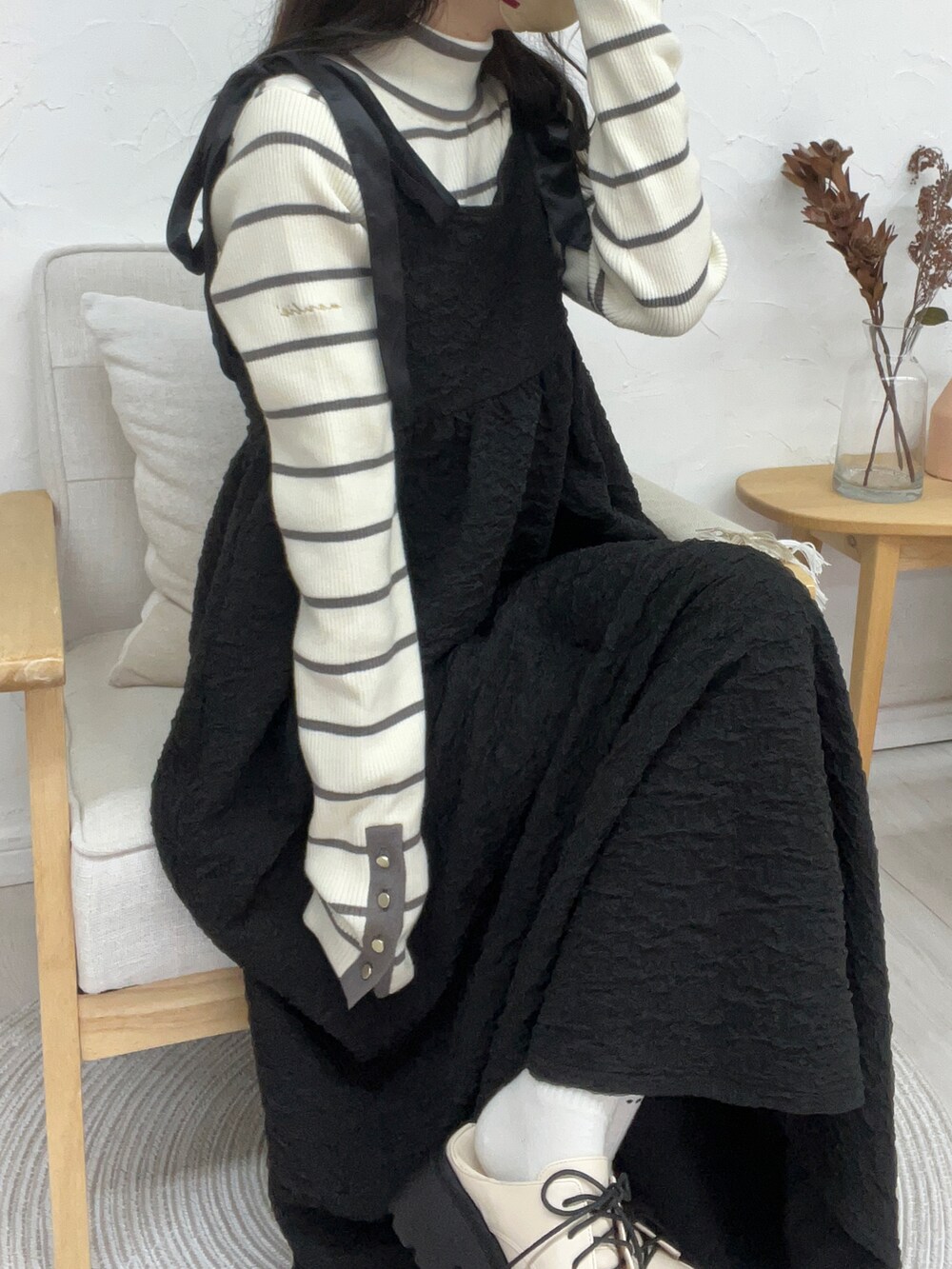 ホワイト系のニット/セーター、イエロー系のワンピース/ドレス、ホワイト系のパンプスを着用したレディースの秋コーディネートの2枚目の写真