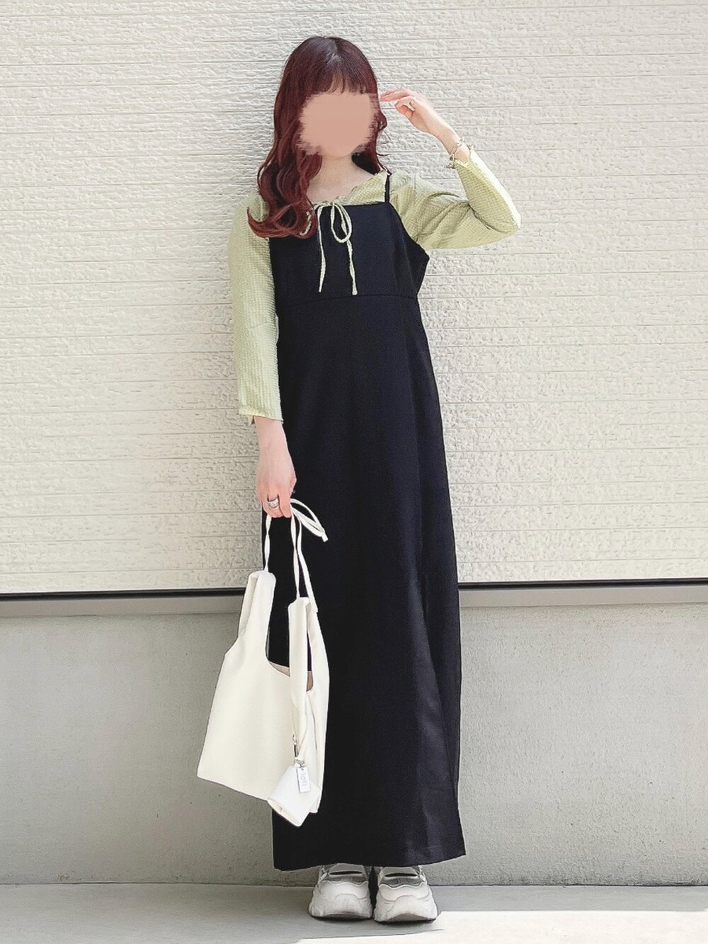 グリーン系のTシャツ/カットソー、ブラック系のワンピース、ホワイト系のスニーカーを着用したレディースの春コーディネートの2枚目の写真