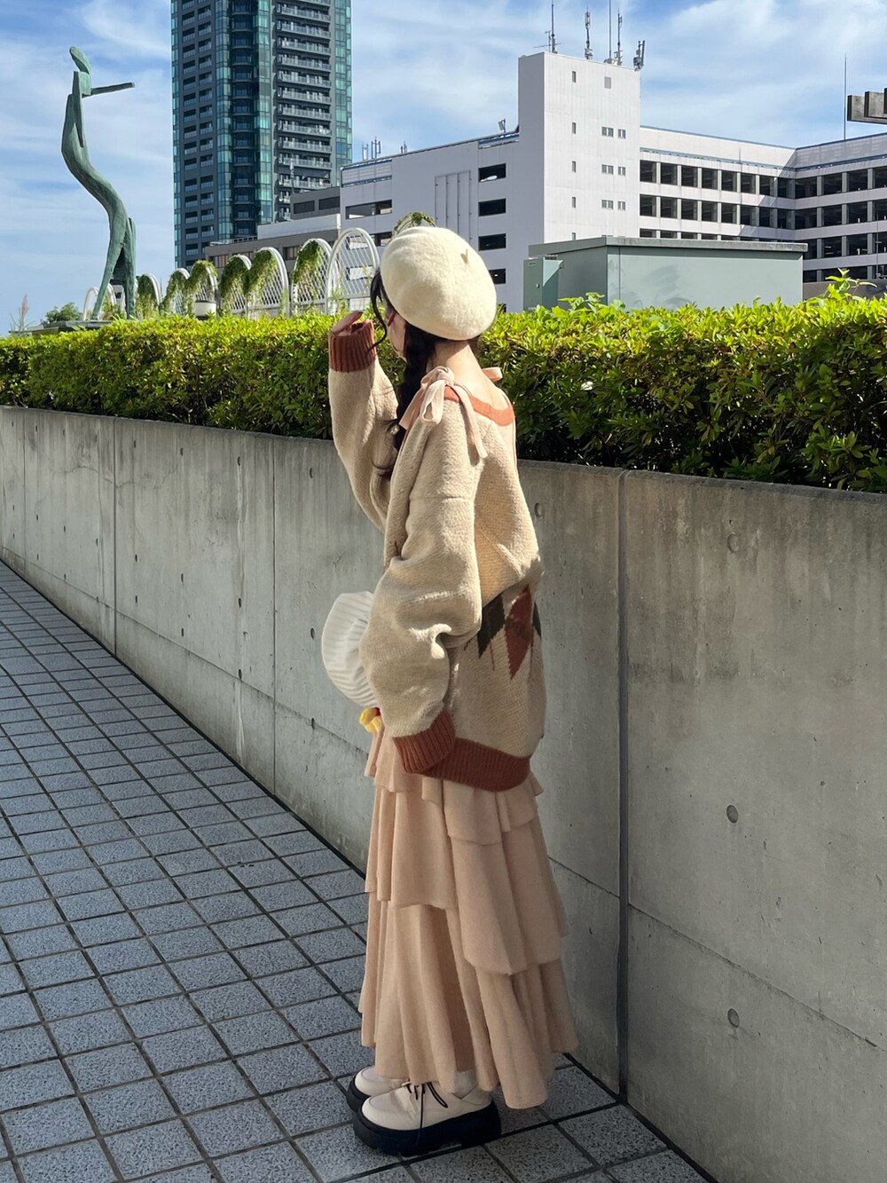 ベージュ系のカーディガン/ボレロ、ホワイト系のパンプスを着用したレディースの冬コーディネートの2枚目の写真