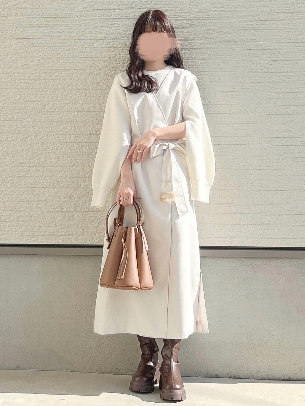 ブラック系のデニムスカート、ブラウン系のブーツを着用したレディースの冬コーディネートの2枚目の写真