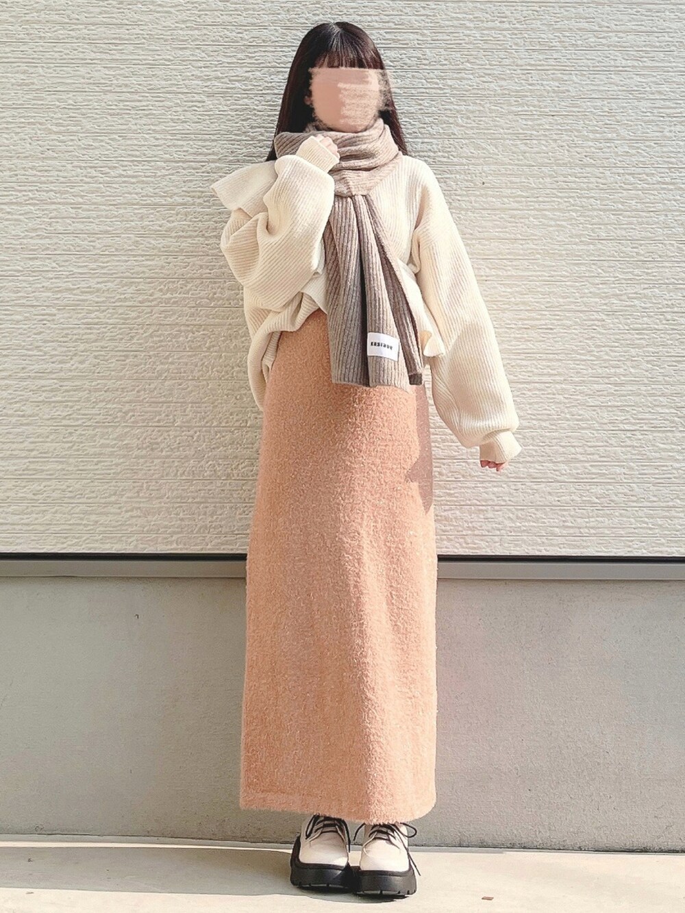 ホワイト系のニット/セーター、ホワイト系のパンプスを着用したレディースの冬コーディネートの2枚目の写真