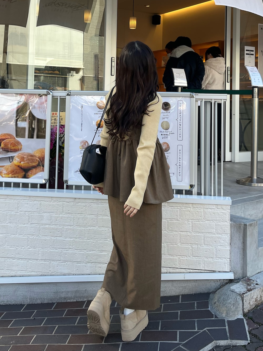 ブラウン系のその他アウター、ブラウン系のワンピース、イエロー系のニット/セーターを着用したレディースの冬コーディネートの2枚目の写真