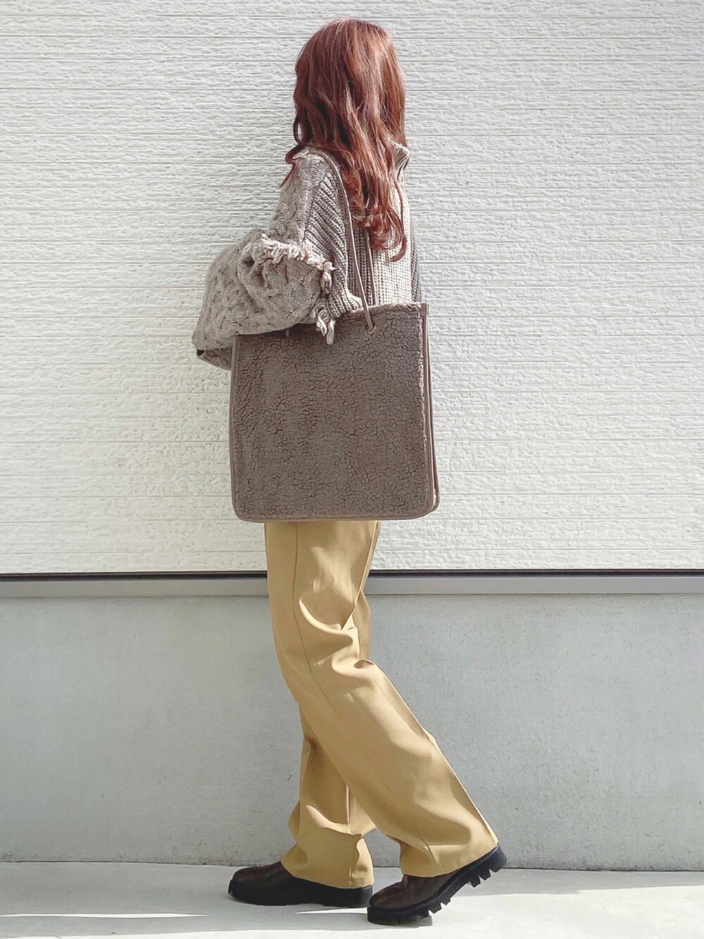 ベージュ系のニット/セーター、イエロー系のスラックス、ブラウン系のトートバッグを着用したレディースの秋コーディネートの3枚目の写真