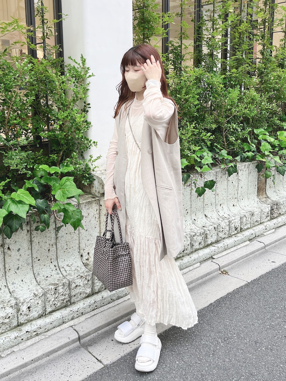 ホワイト系のワンピース、グレー系のベスト、ホワイト系のサンダルを着用したレディースの夏コーディネートの3枚目の写真