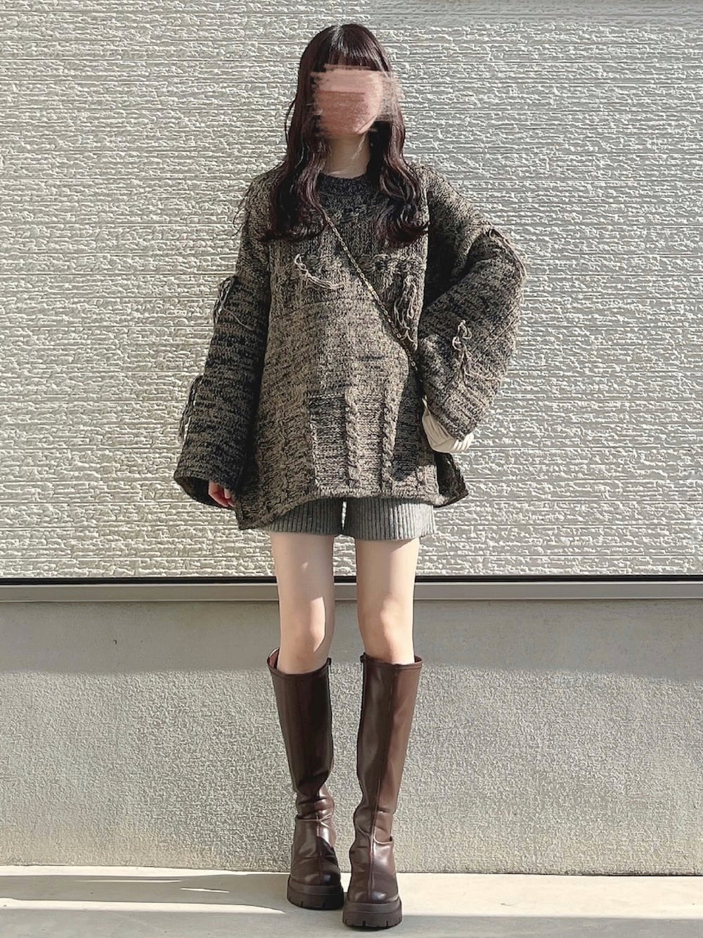 ベージュ系のニット/セーター、ベージュ系のショルダーバッグ、ブラウン系のブーツを着用したレディースの冬コーディネートの2枚目の写真