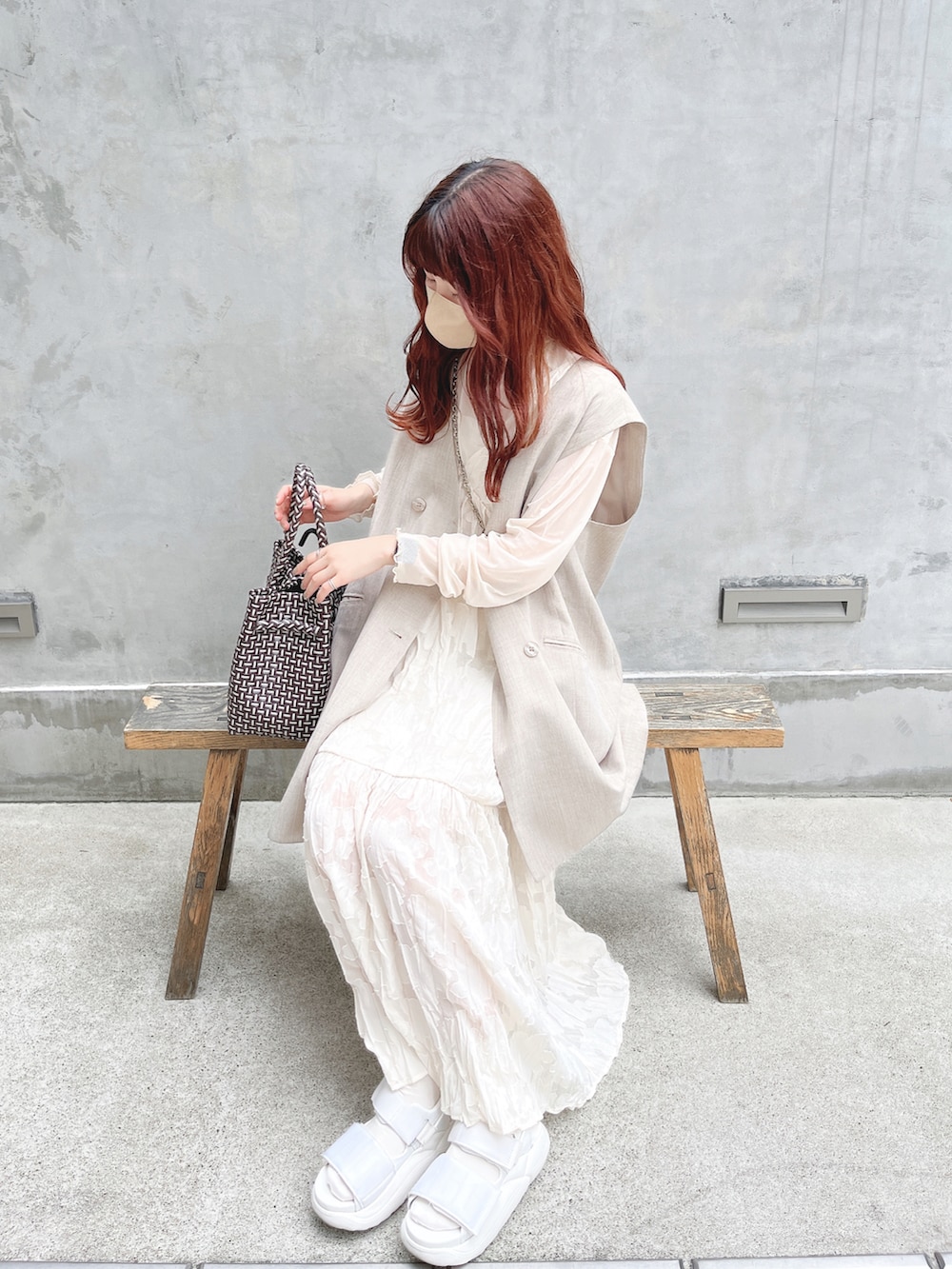 ホワイト系のワンピース、グレー系のベスト、ホワイト系のサンダルを着用したレディースの夏コーディネートの2枚目の写真